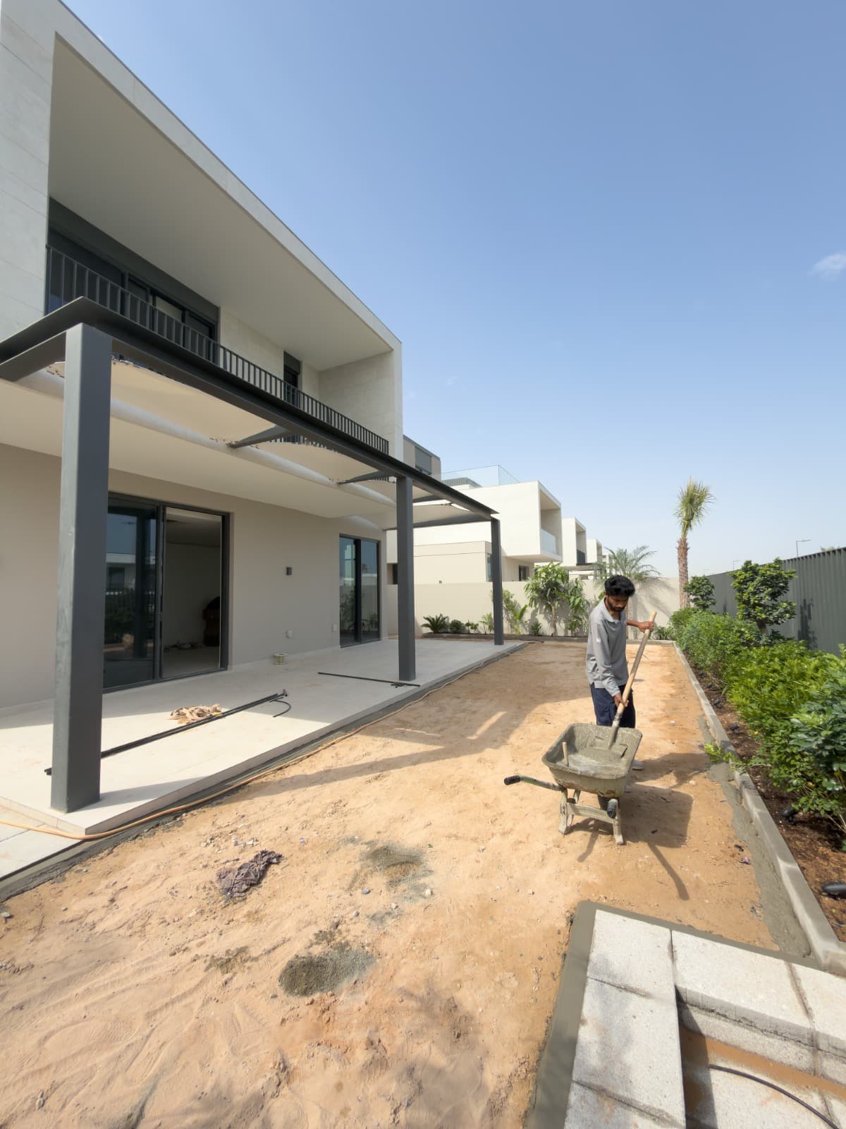 The same villa garden before installation, bare sand