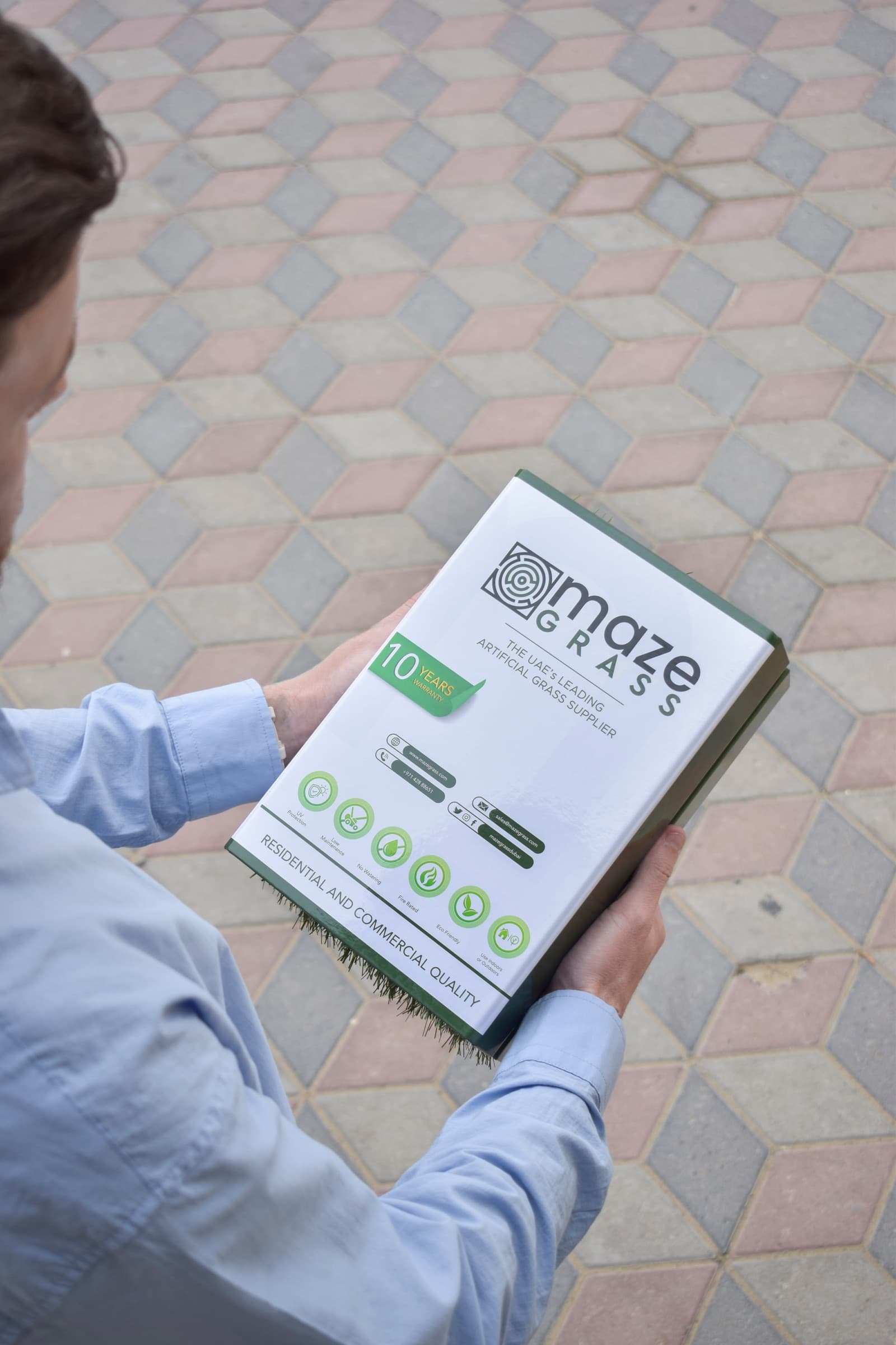 Customer holding a Maze Grass sample pack, choosing their artificial grass