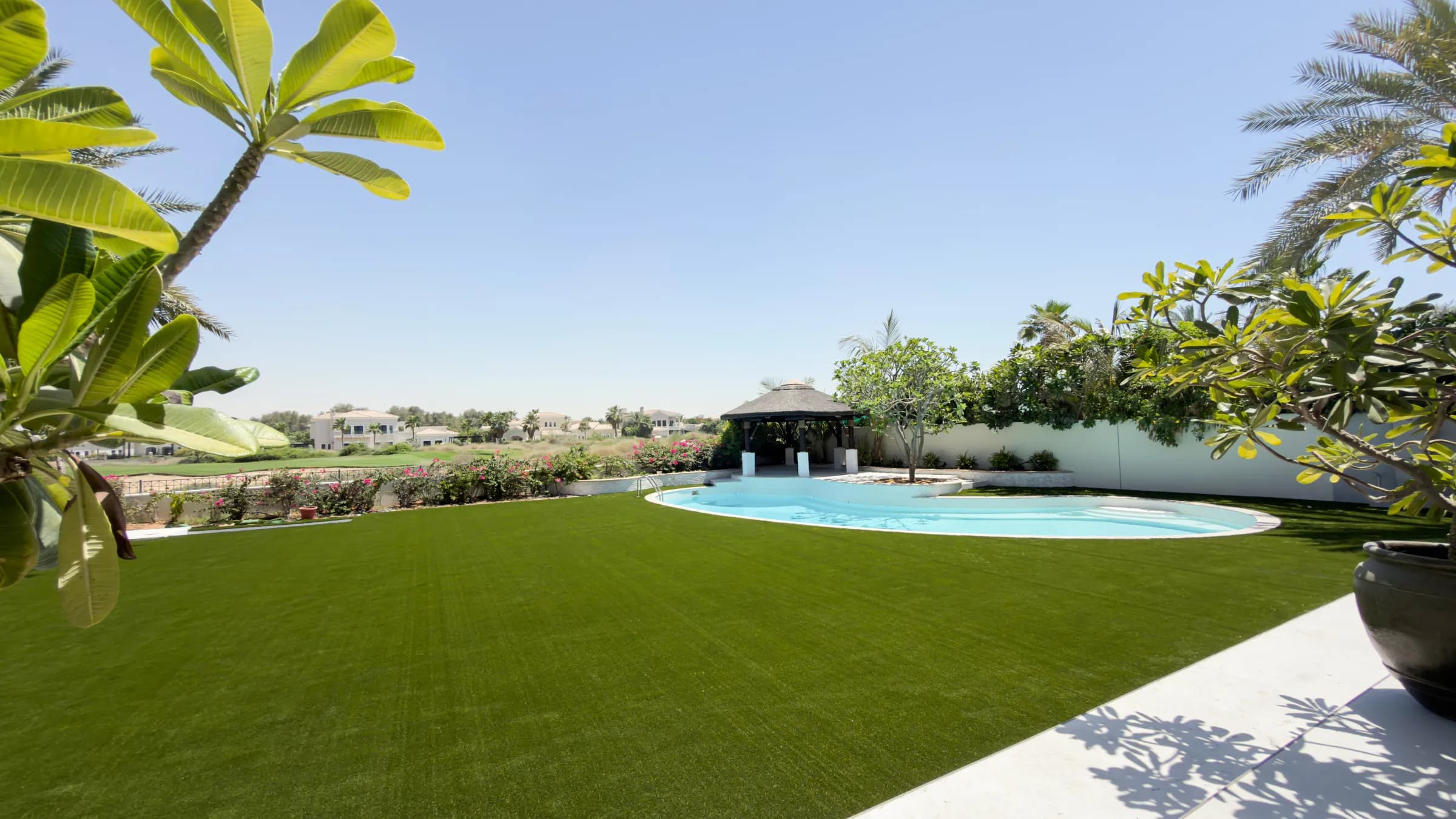 A large Maze artificial grass lawn sweeping around the pool of a villa at Saheel, Arabian Ranches